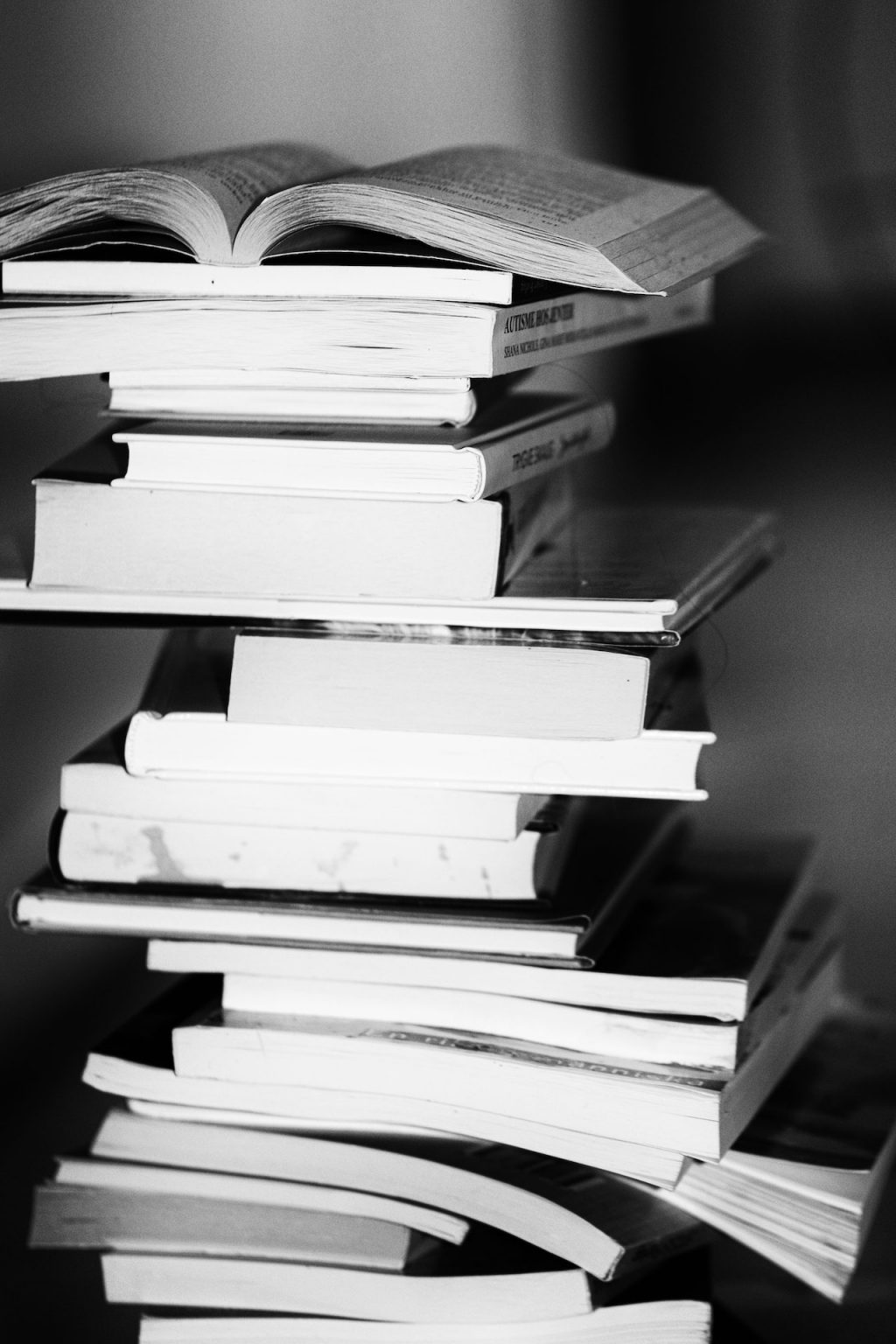 stacks of books in black and white; research question examples